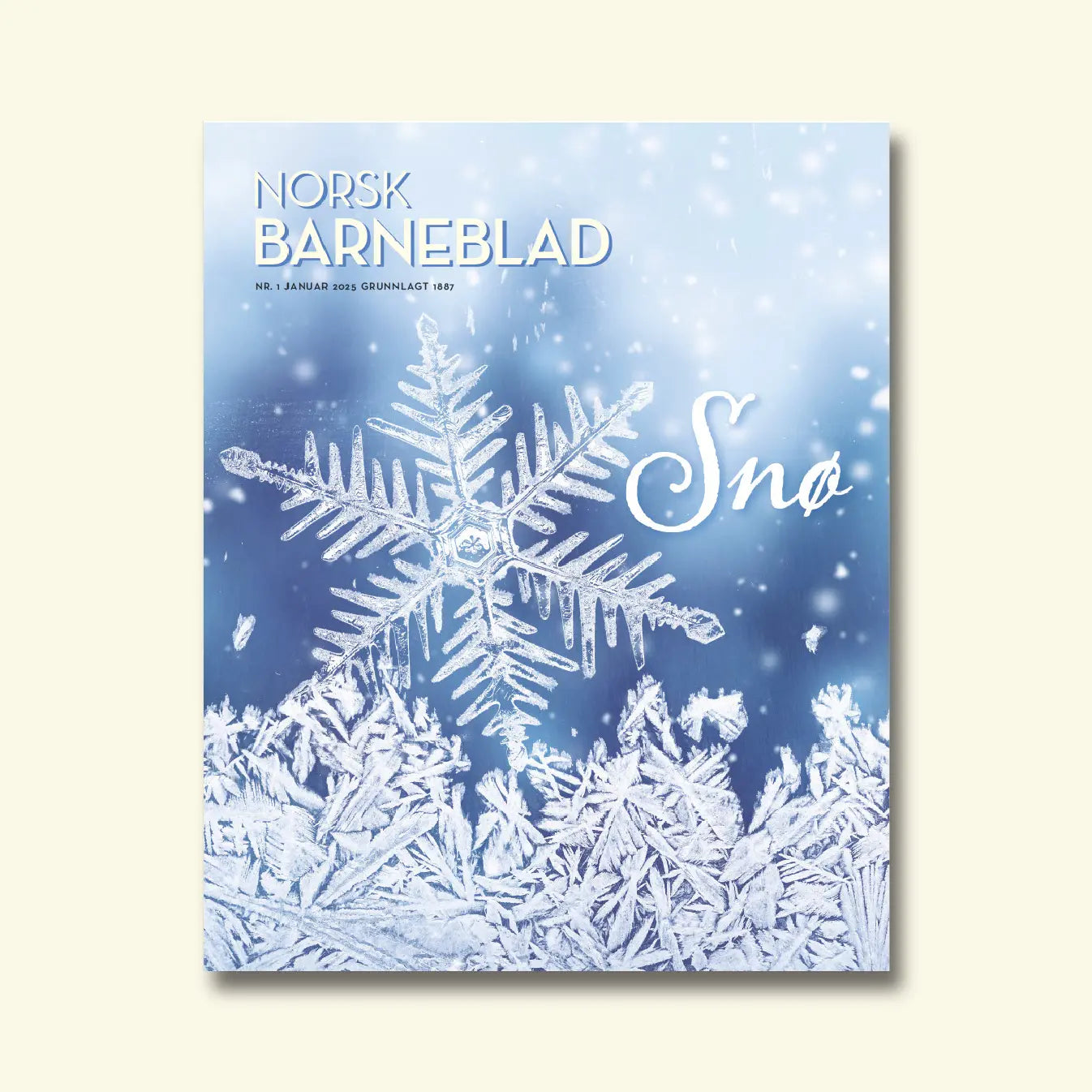 Norsk Barneblad, nr. 1 januar 2025, framside med ein nærbilete av ein snøkrystall over rimfrost mot ein blå bakgrunn